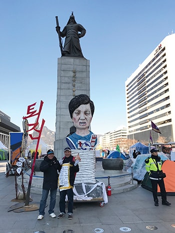 Tác giả chụp hình tại quảng trường Gwanghwamun với người biểu tình dưới chân tượng Tướng quân Lee Sung Shin