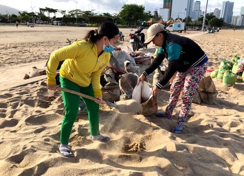 Người dân xúc đất trên bãi biển Nha Trang để chằng chống nhà cửa.