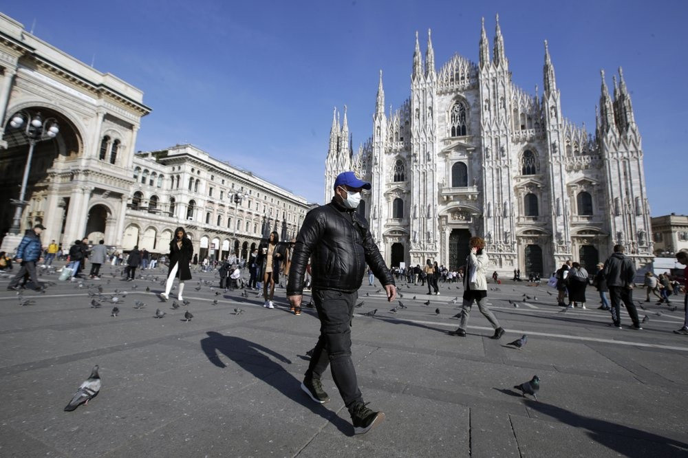 Một người đeo khẩu trang đi trước nhà thờ Duomo ở Milan, Italy, hôm 24/2 - Ảnh: AP
