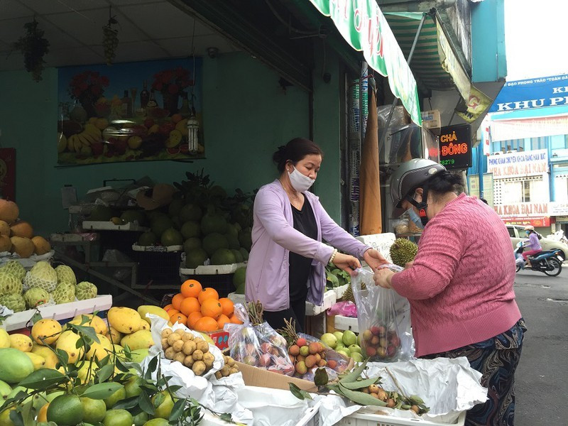 Người tiêu dùng mua trái cây tại chợ