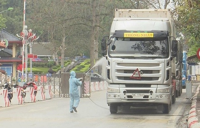 Lực lượng chức năng tỉnh Lạng Sơn tổ chức phun khử khuẩn các phương tiện vận chuyển hàng hóa XNK - Ảnh: T. Dũng
