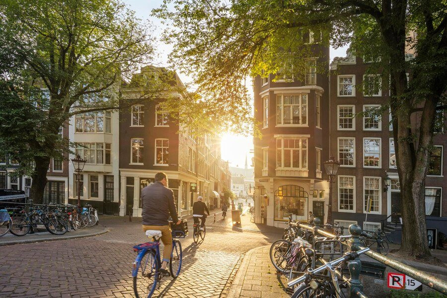 amsterdam-netherlands-september-22-2021-people-ride-bike-early-morning-amsterdam-sunny-quiet-street-ancient-european-city-amsterdam-holland-netherlands-europe_638259-1514.jpeg