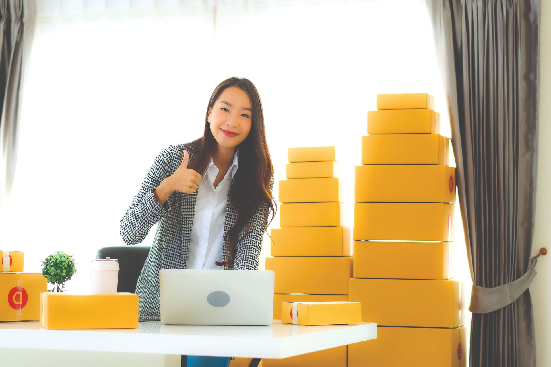 portrait-beautiful-young-asian-business-woman-work-from-home-with-laptop-mobile-phone-with-cardboard-box-ready-shipping-compressed.jpeg