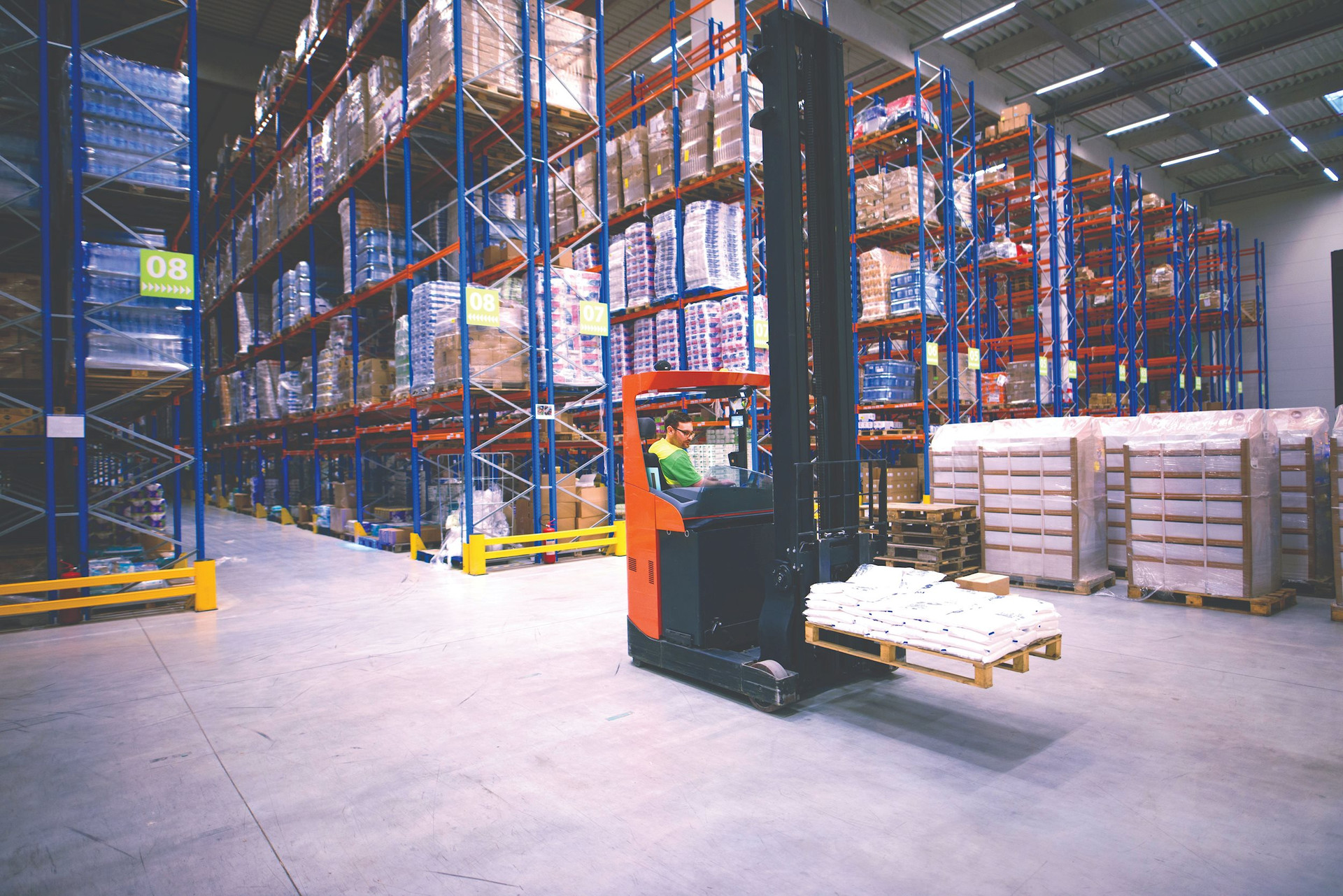 worker-operating-forklift-machine-relocating-goods-large-warehouse-center-compressed.jpeg