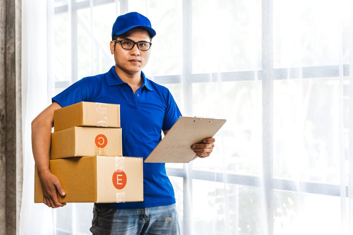 asian-delivery-man-holding-package-boxes-front-1-.jpg