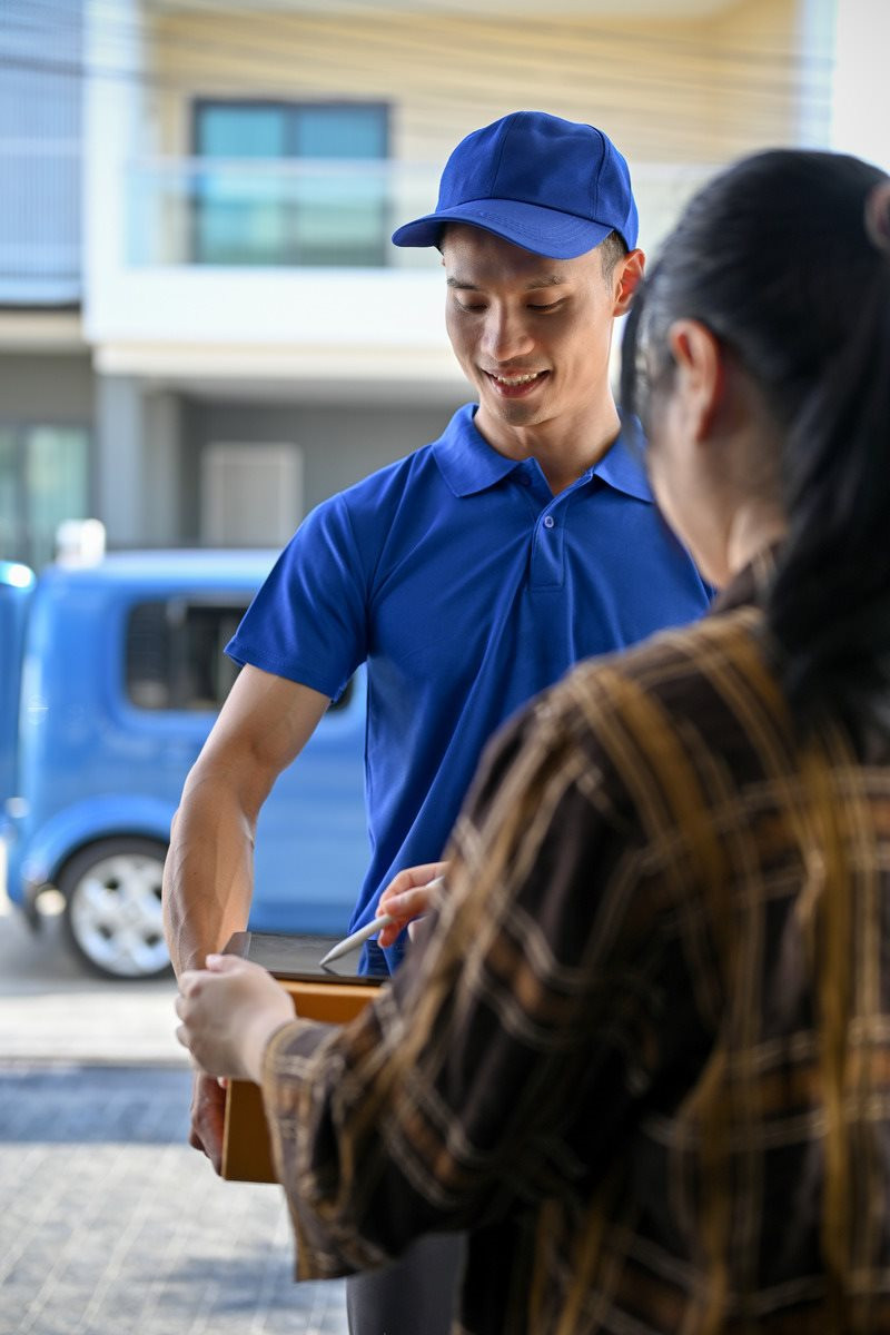 young-asian-delivery-man-handing-parcel-customer-have-customer-sign-tablet-1-.jpg