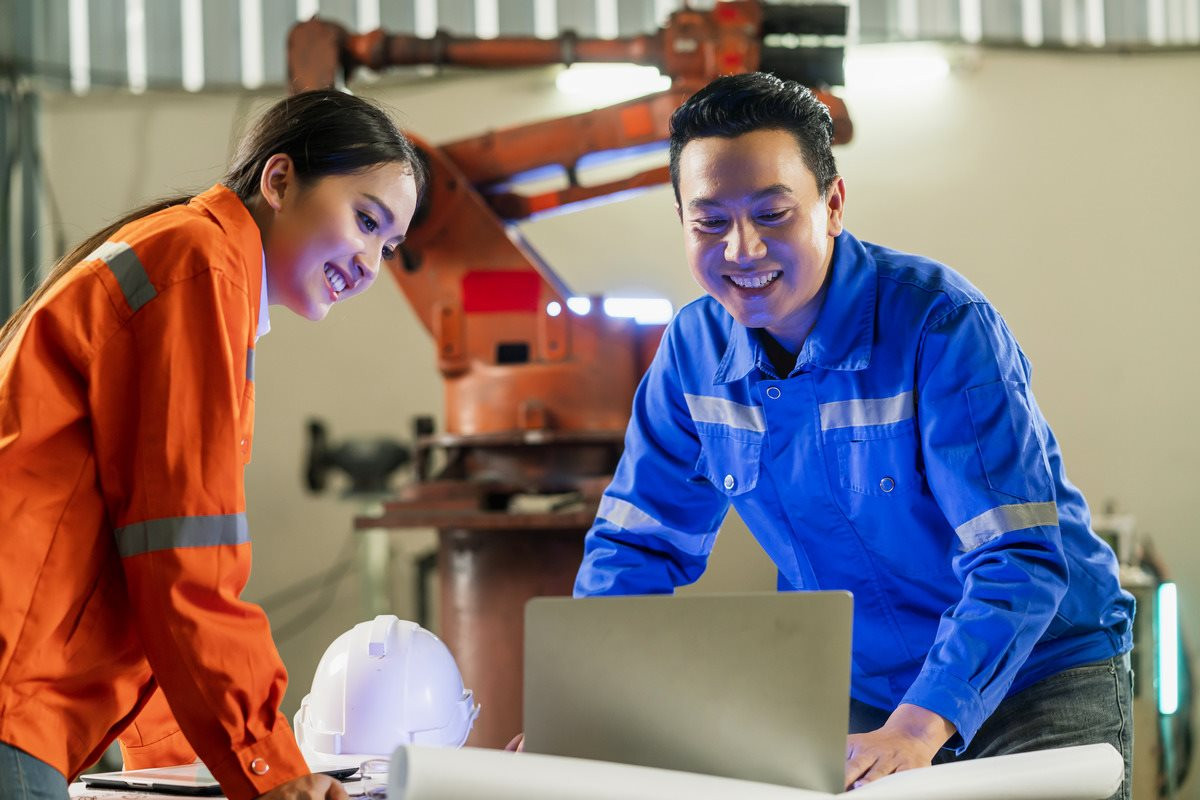 engineer-cooperation-two-asian-male-female-technician-maintenance-inspect-relay-robot-system-with-tablet-laptop-control-quality-operate-process-work-heavy-industry-40-manufacturing-factory-1-.jpg