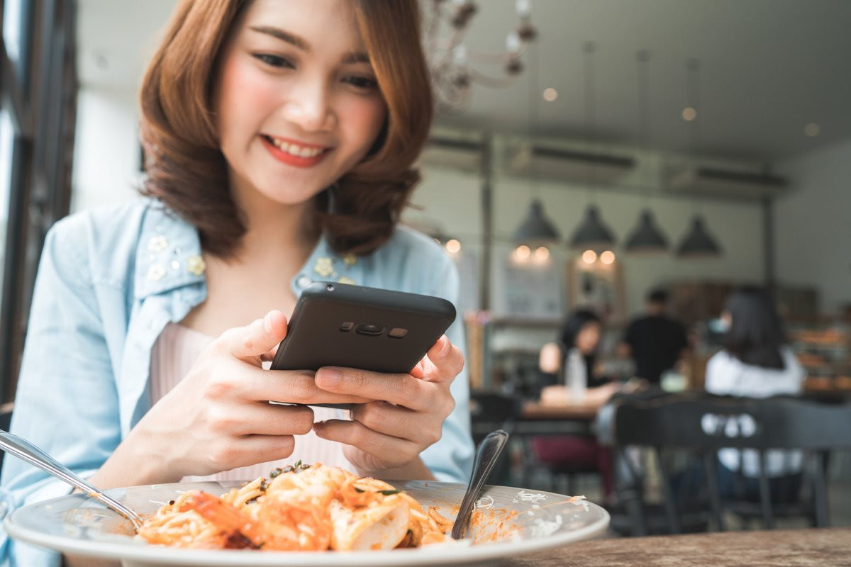 female-blogger-photographing-lunch-restaurant-with-her-phone-1-.jpg